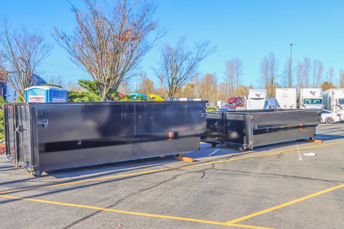 Professional dumpster rental service with roll-off container on residential driveway in Manville